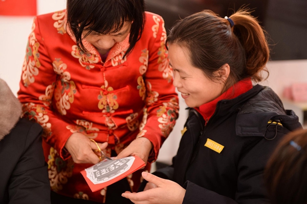 王德蕊老师手把手教导社区工作人员如何剪纸.